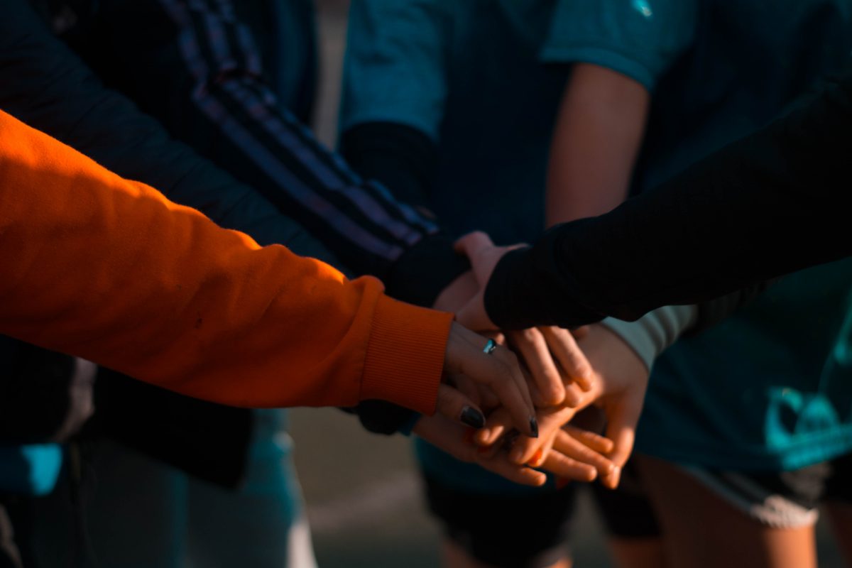 people in huddle join hands