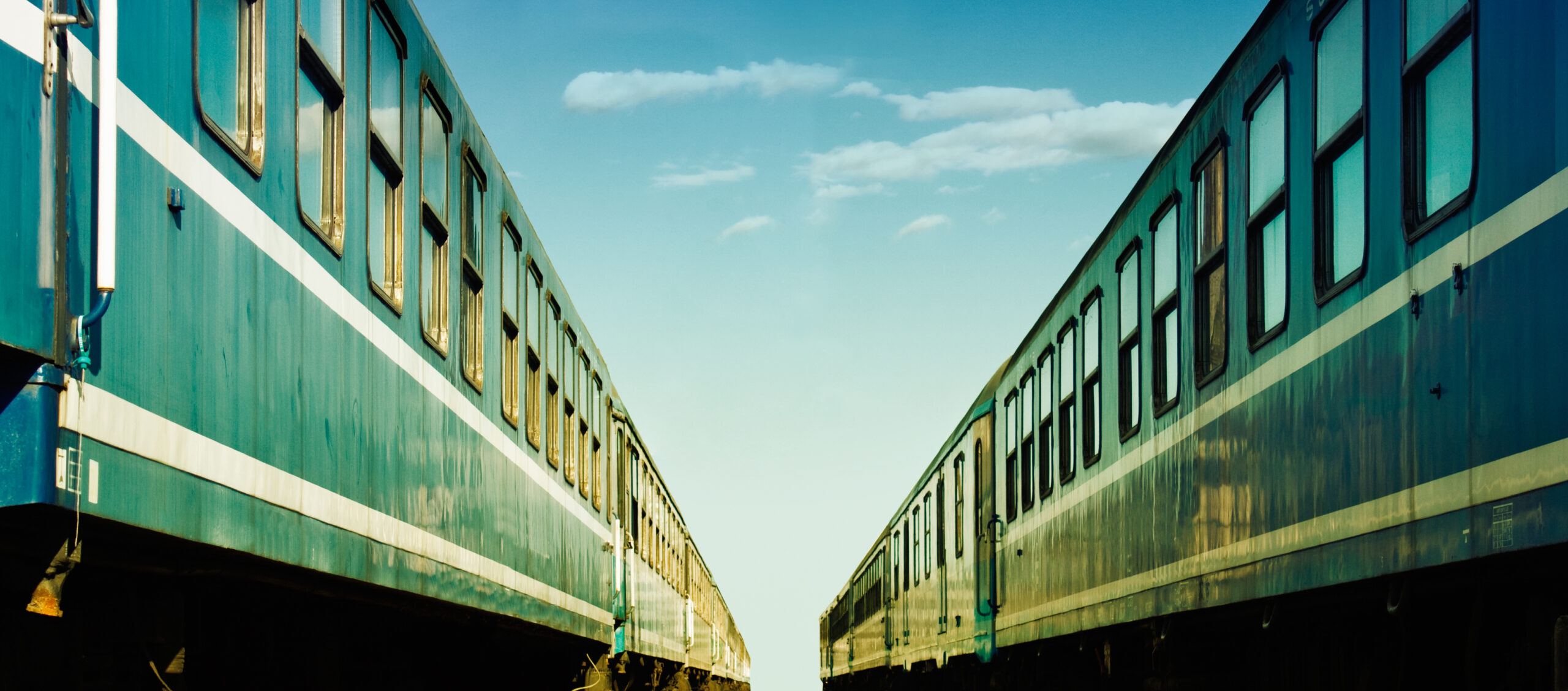 Two trains at the train station with blue sky background.