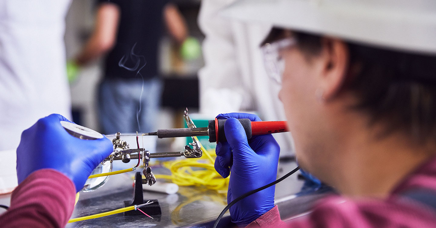 high bay lab - student works on electrical probe