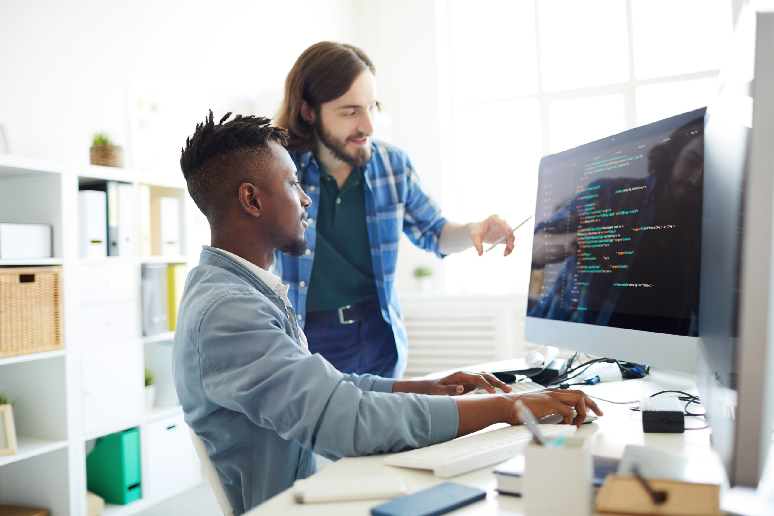 software developers, two co-workers decoding data on computer screen