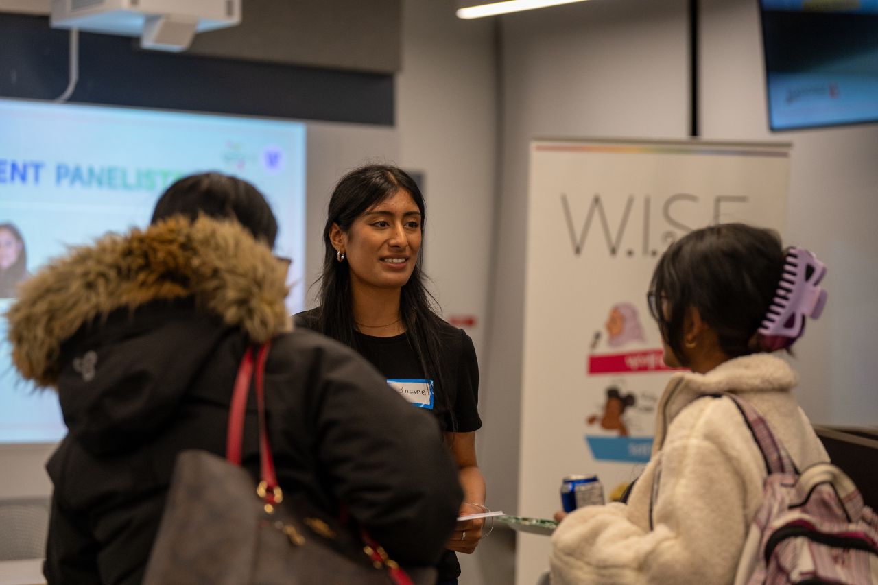 Image of Women In Science and Engineering club hosting an event. Woman providing information to students