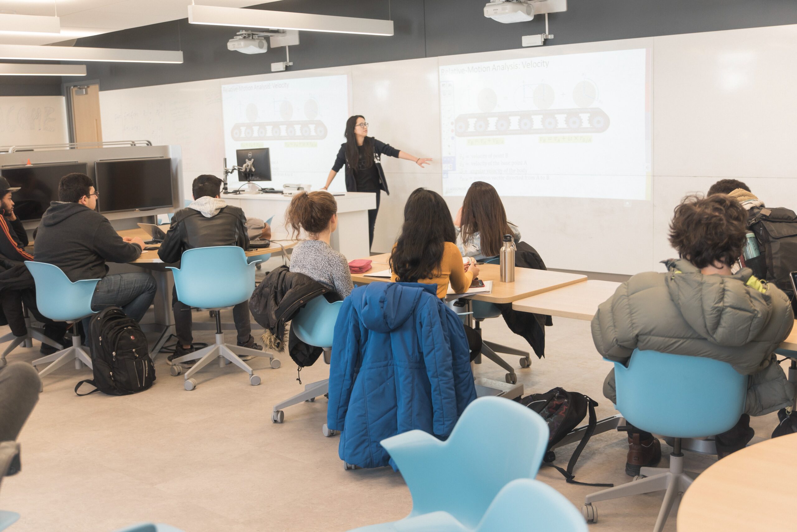 Image of a full classroom of a prof teaching engineering students through the use of a digital screen