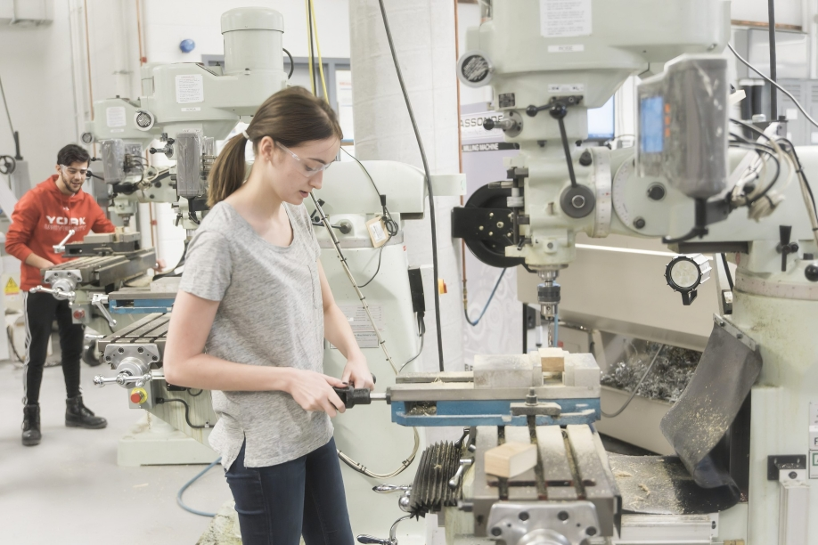 young female engineering working in a machine lab