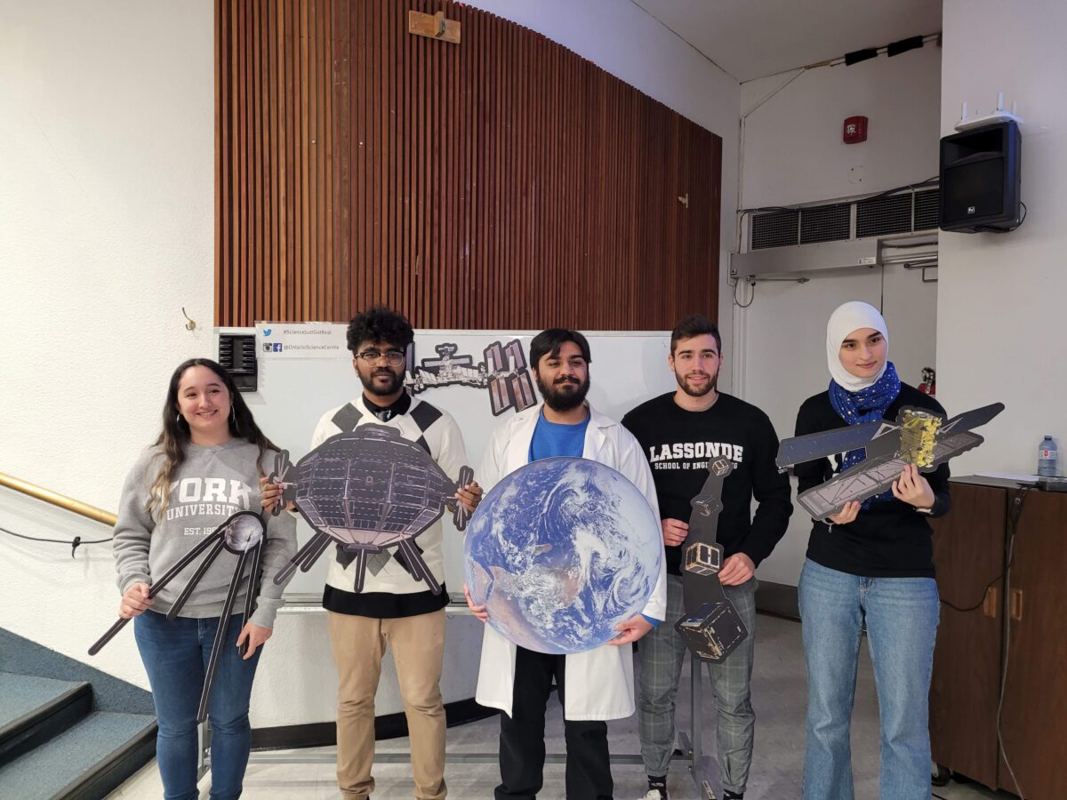 Professor Lee’s graduate students posing with props used in presentations at the Ontario Science Centre. 