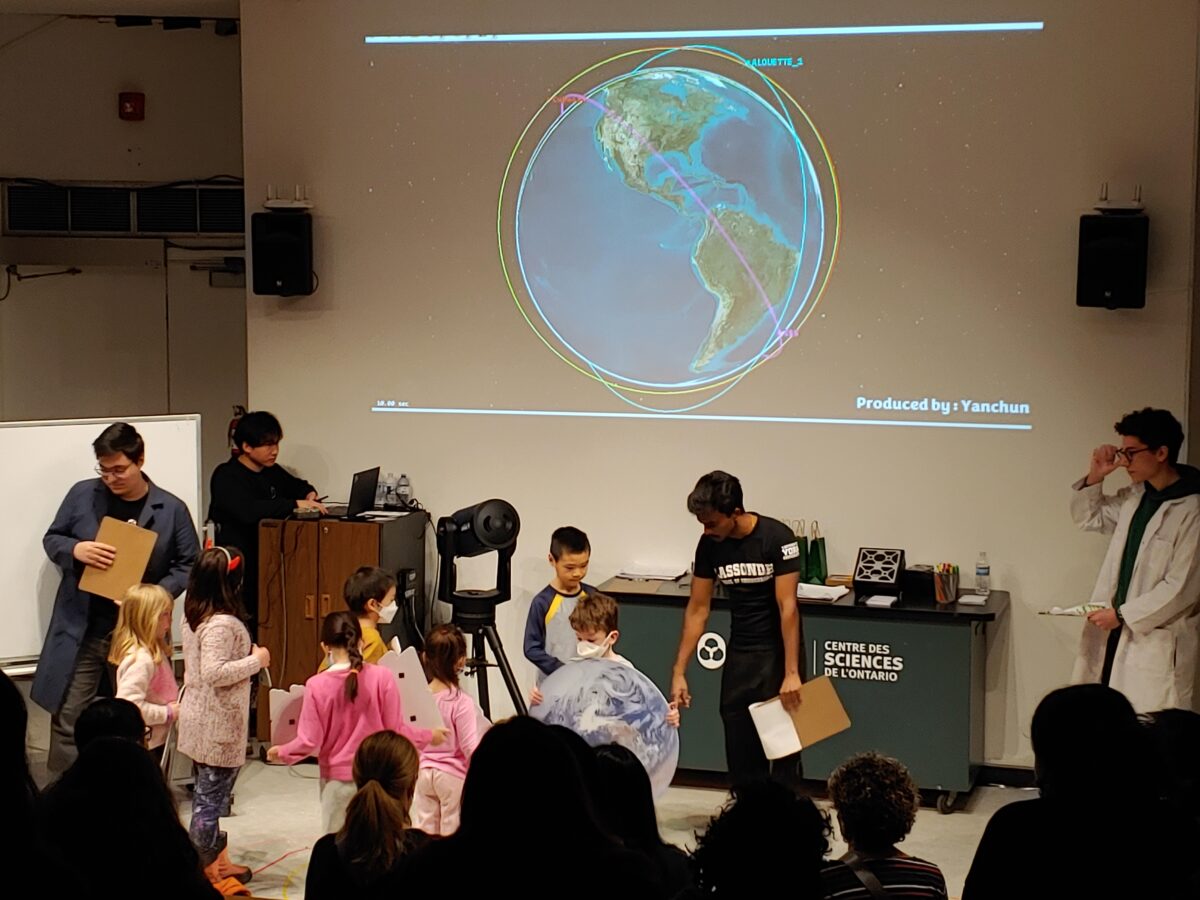Professor Lee’s graduate students leading an interactive demonstration with children in the audience.