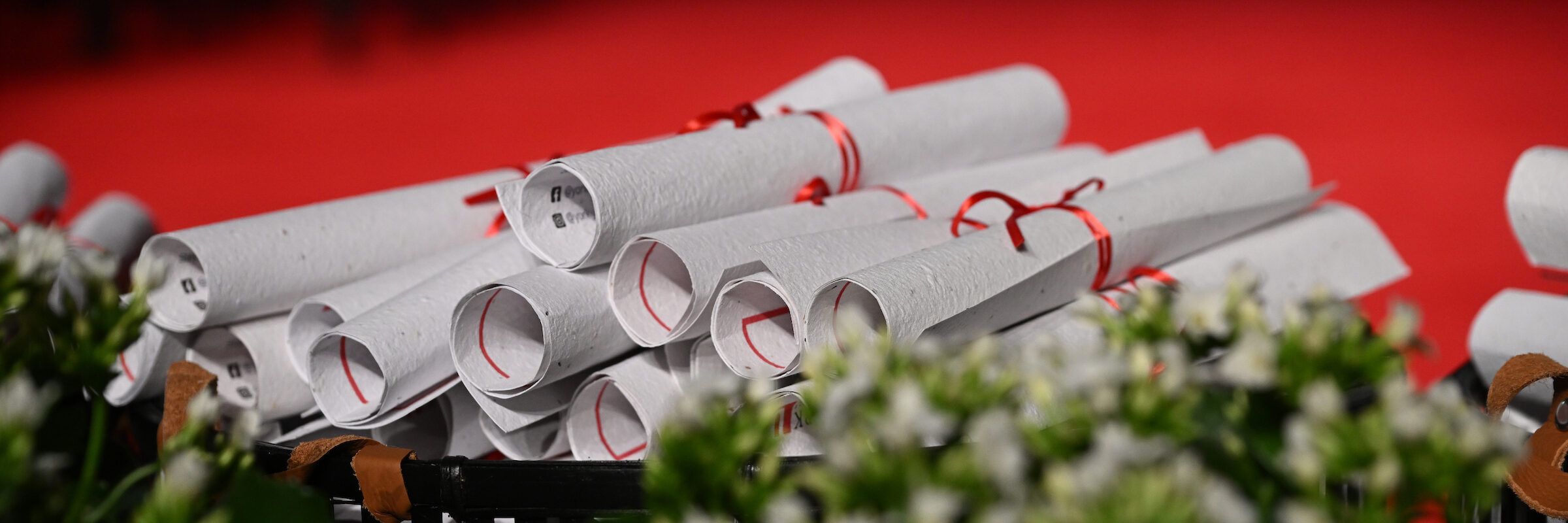 A picture of multiple envelopes with a red ribbon wrapped around them.