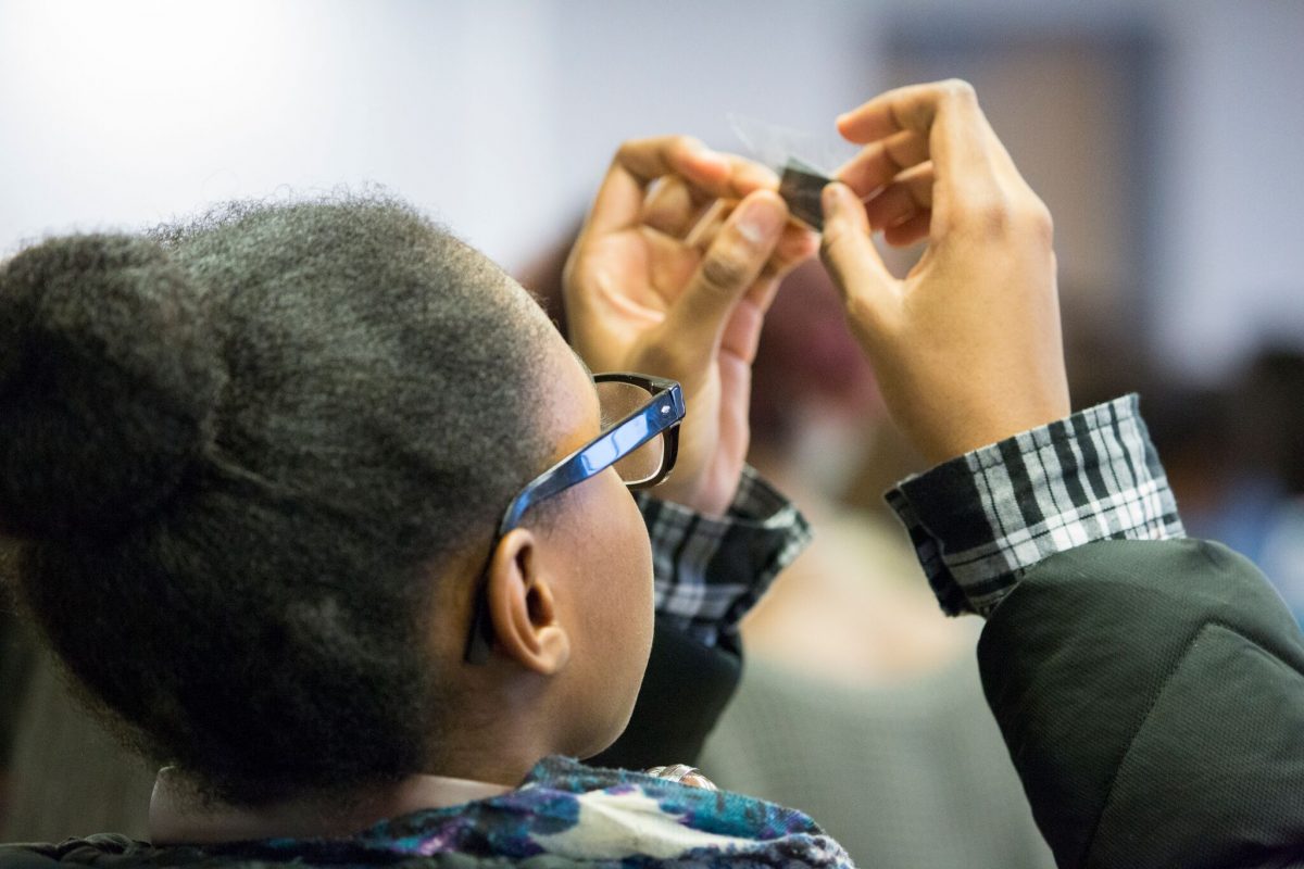 Photo of a student looking through a lens as part of an Engineering activity