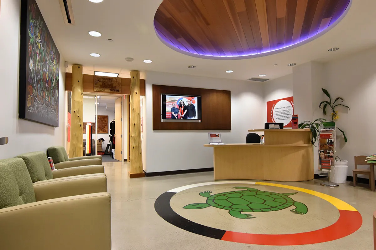 An office foyer with couches and a receptionist desk.