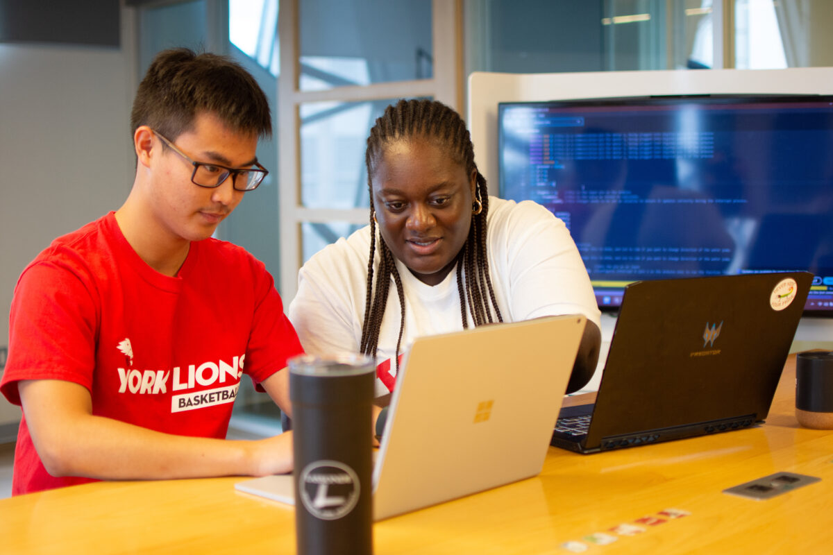 Mentor helping student on laptop