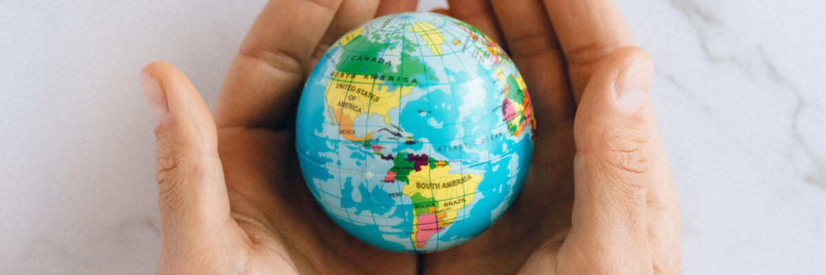 A pair of hands holding a mini globe