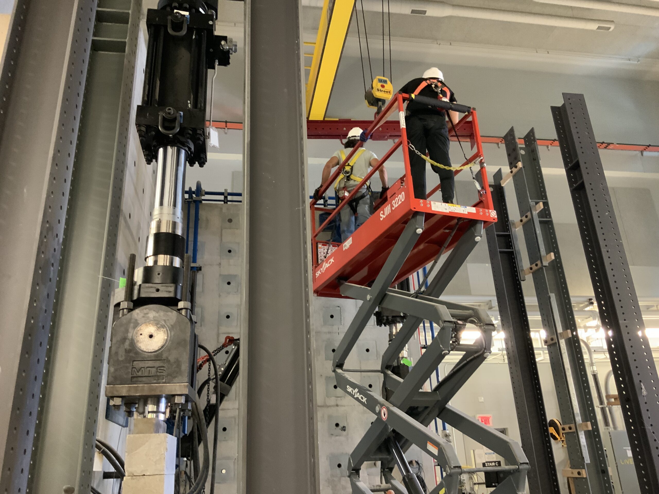 2 Civil Engineering students on top of a scissor lift.