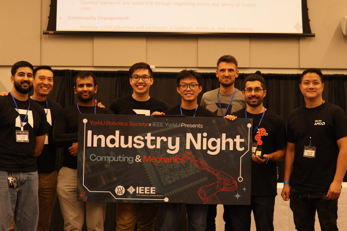 AMD engineers posing with their People’s Choice Award and Industry Night banner. 