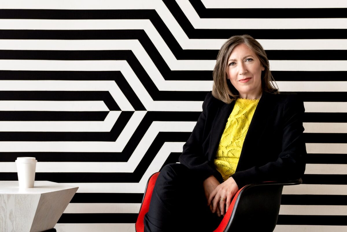 portrait of Jane Goodyer, red chair, black and white stripes background