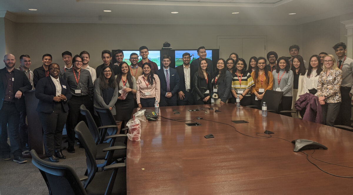 A large group of people standing in a conference room