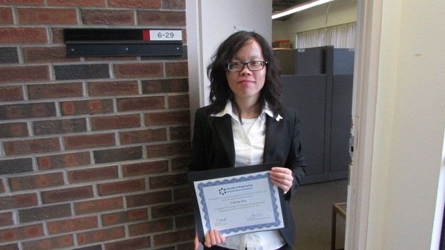 Professor Cuiying Jian during her PhD studies, posing with her Best Presentation Award from the annual Faculty of Engineering Graduate Research Symposium.