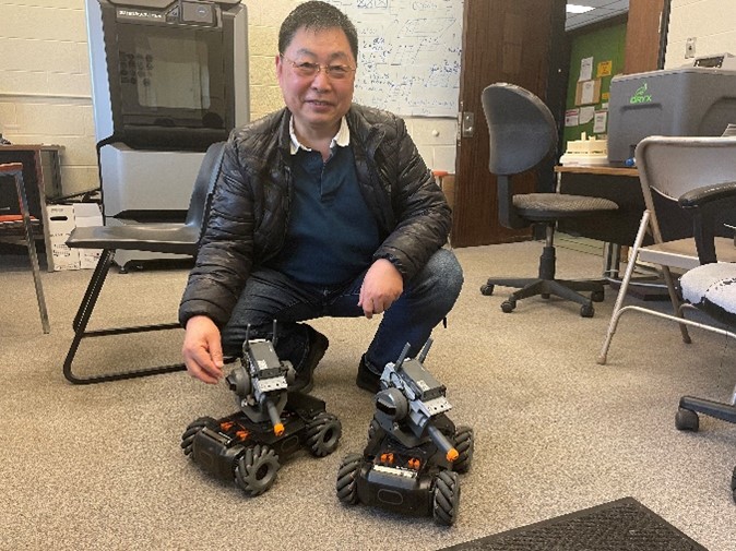 George Zhu with robotic vehicles used to mimic small, swarm satellites