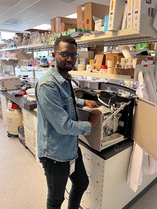 Ogato tinkers with his repurposed bioprinter in his lab. 