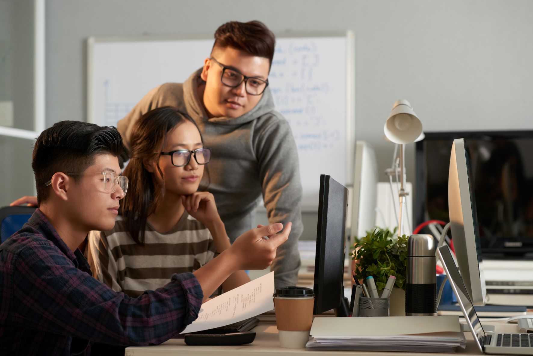 three students looking at laptop