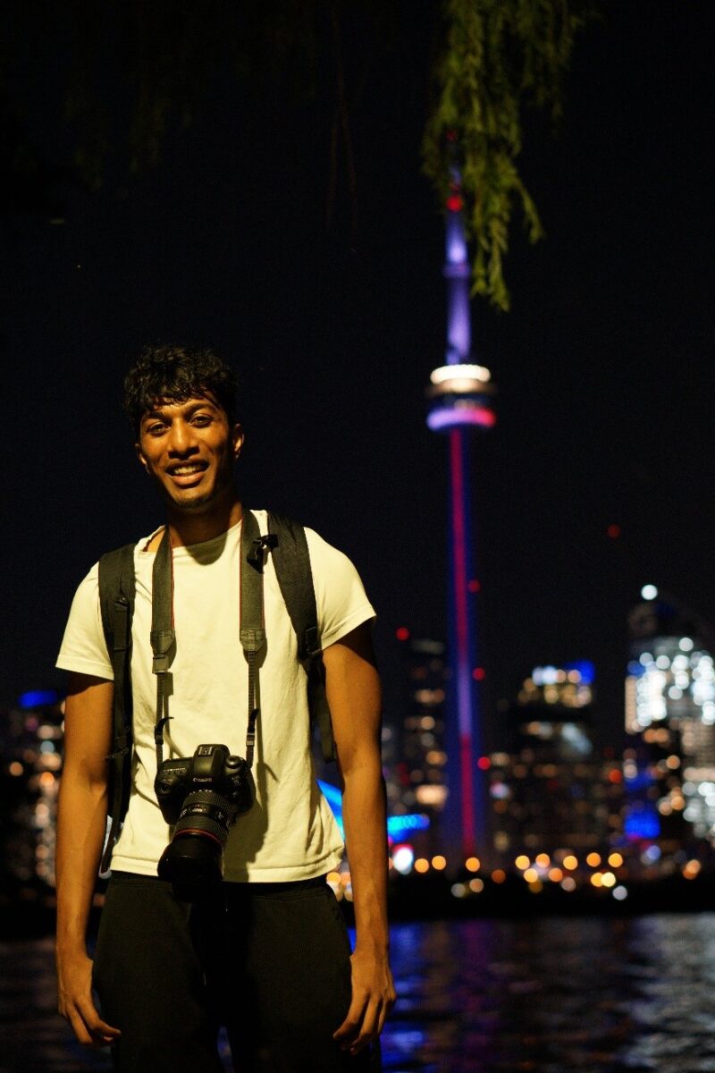 Young man standing at night with CN in the background