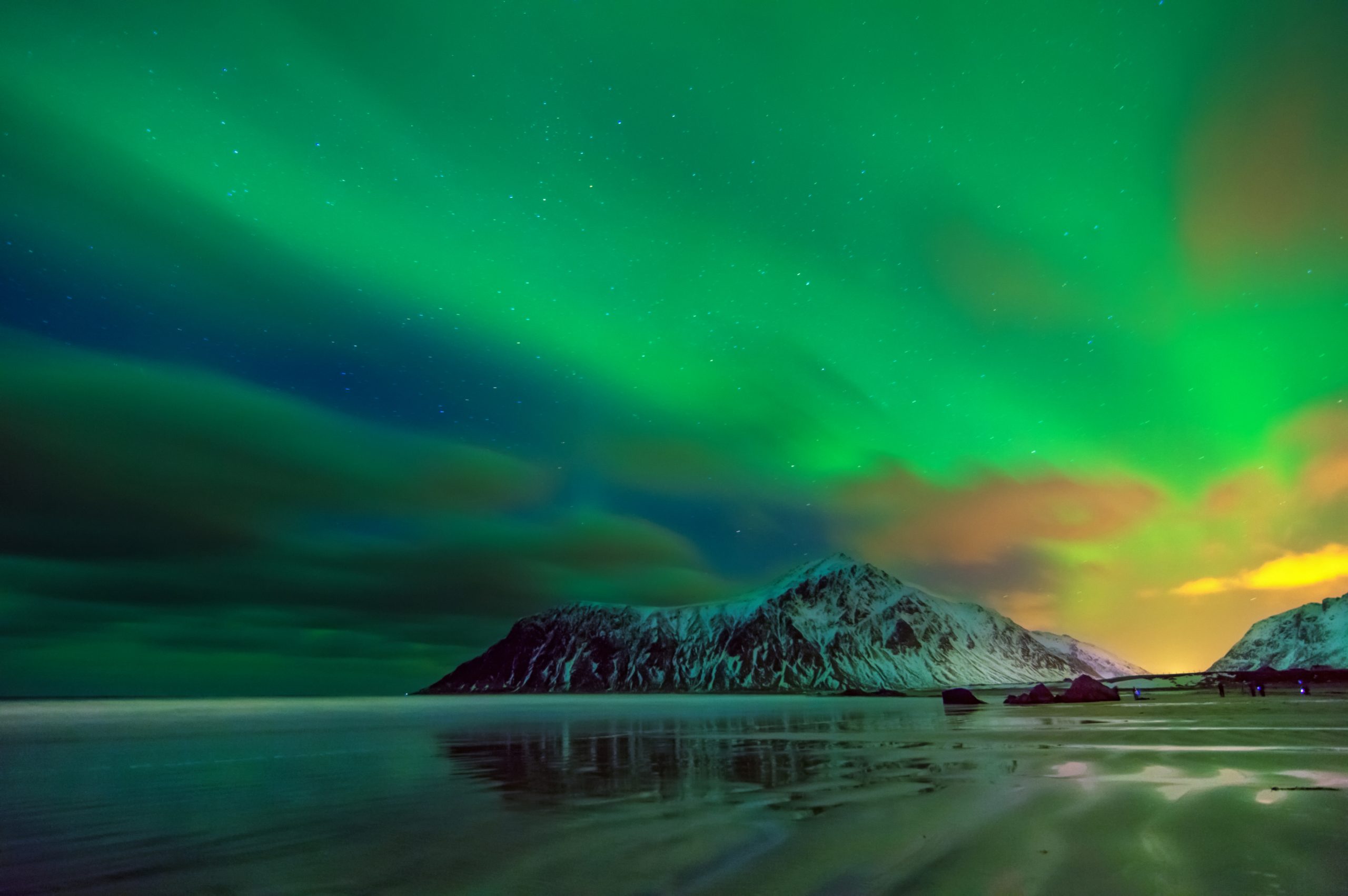 Aurora borealis over snowy islands from Uttakleiv beach of Lofoten, Norway