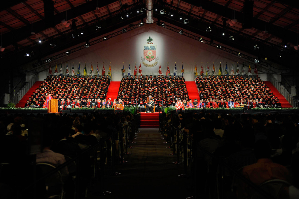 A stage of graduates at a convocation ceremony
