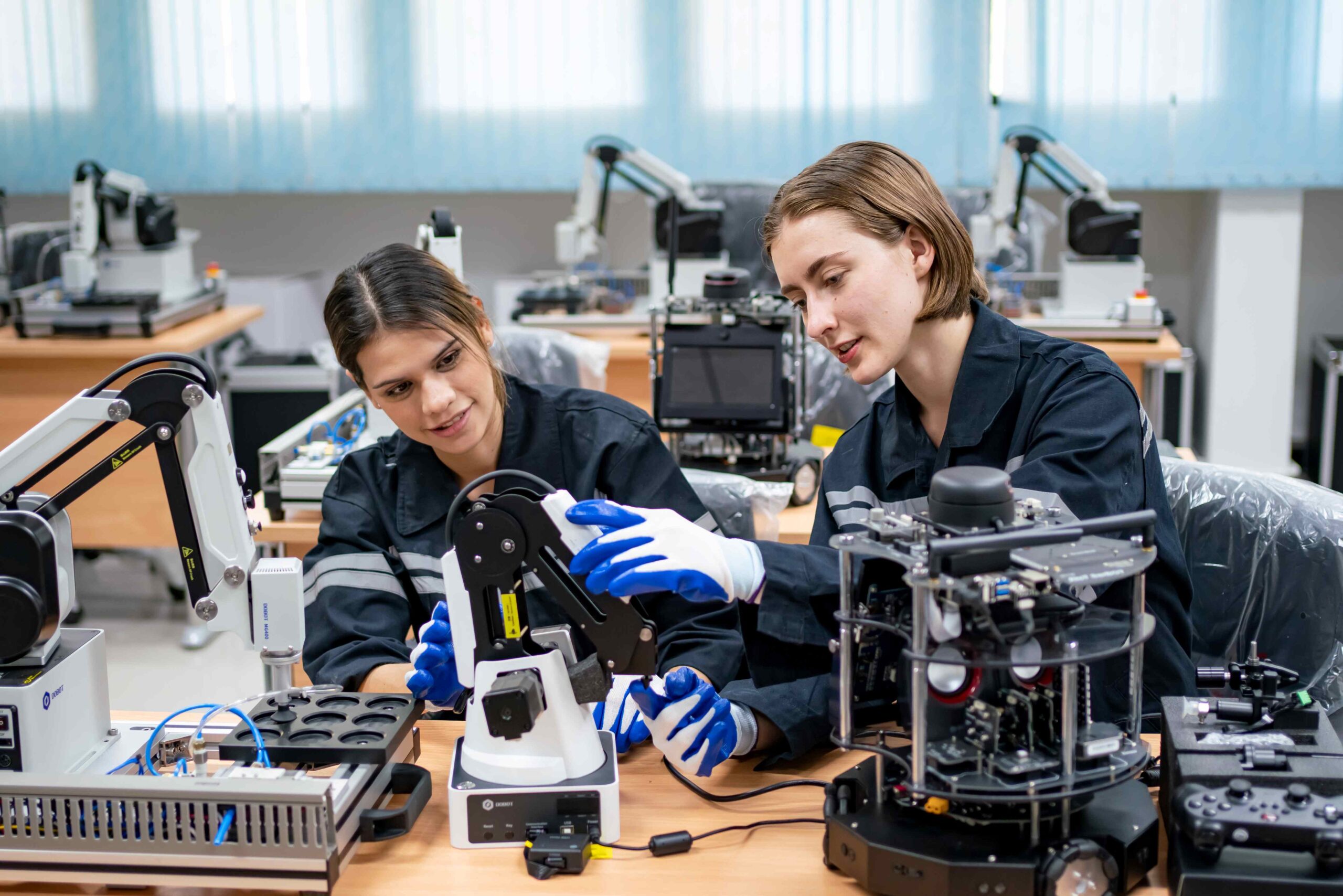 Two young female engineers working on robotics