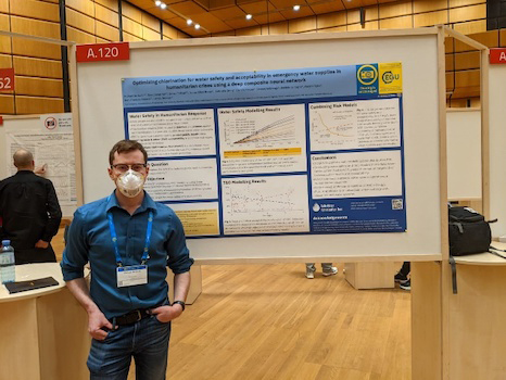 a man standing in front of a research poster board