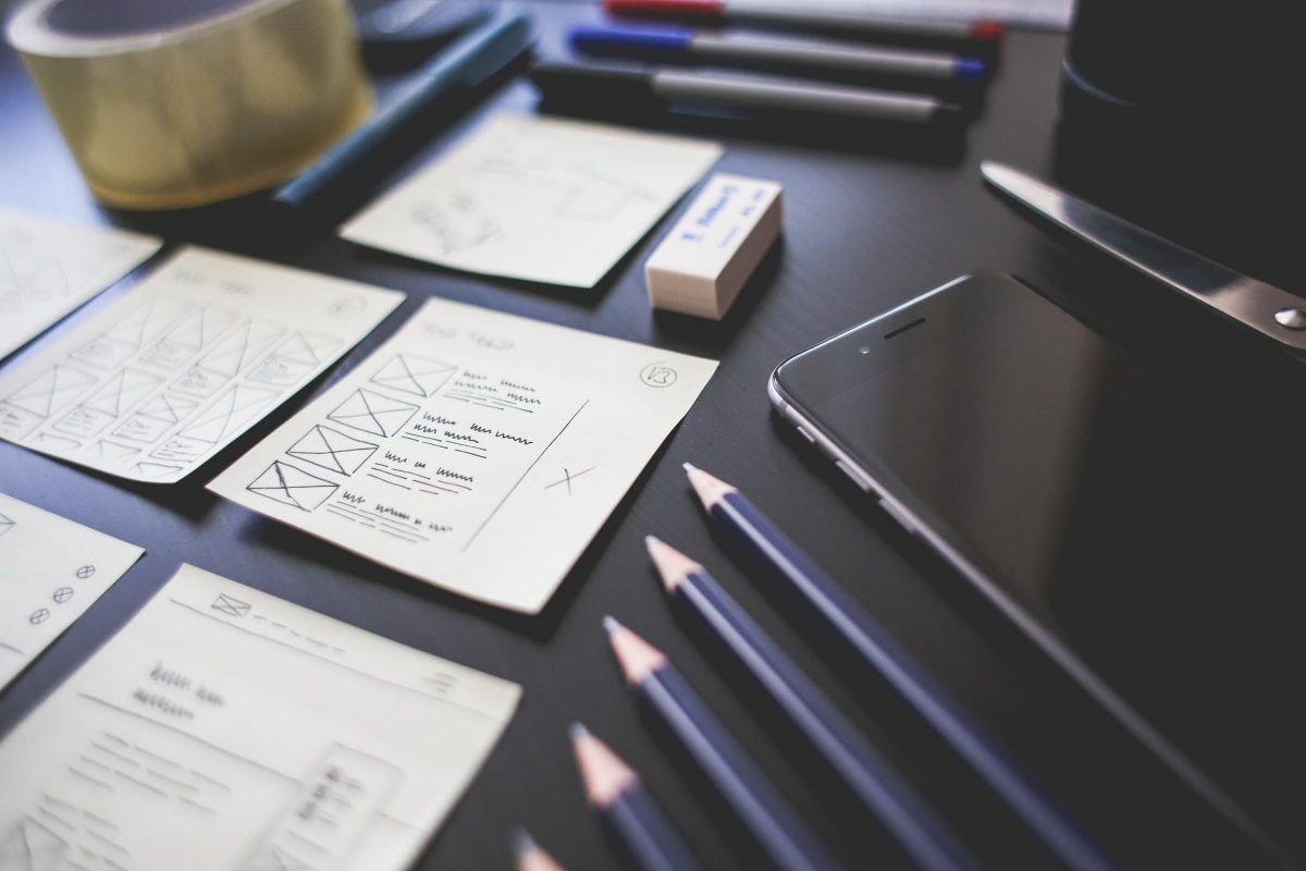 desk with pens, pad of paper, phone