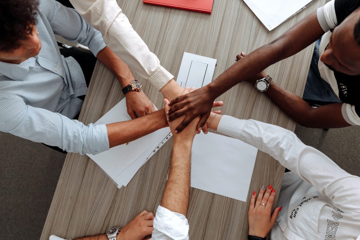 People put hands together in go team motion