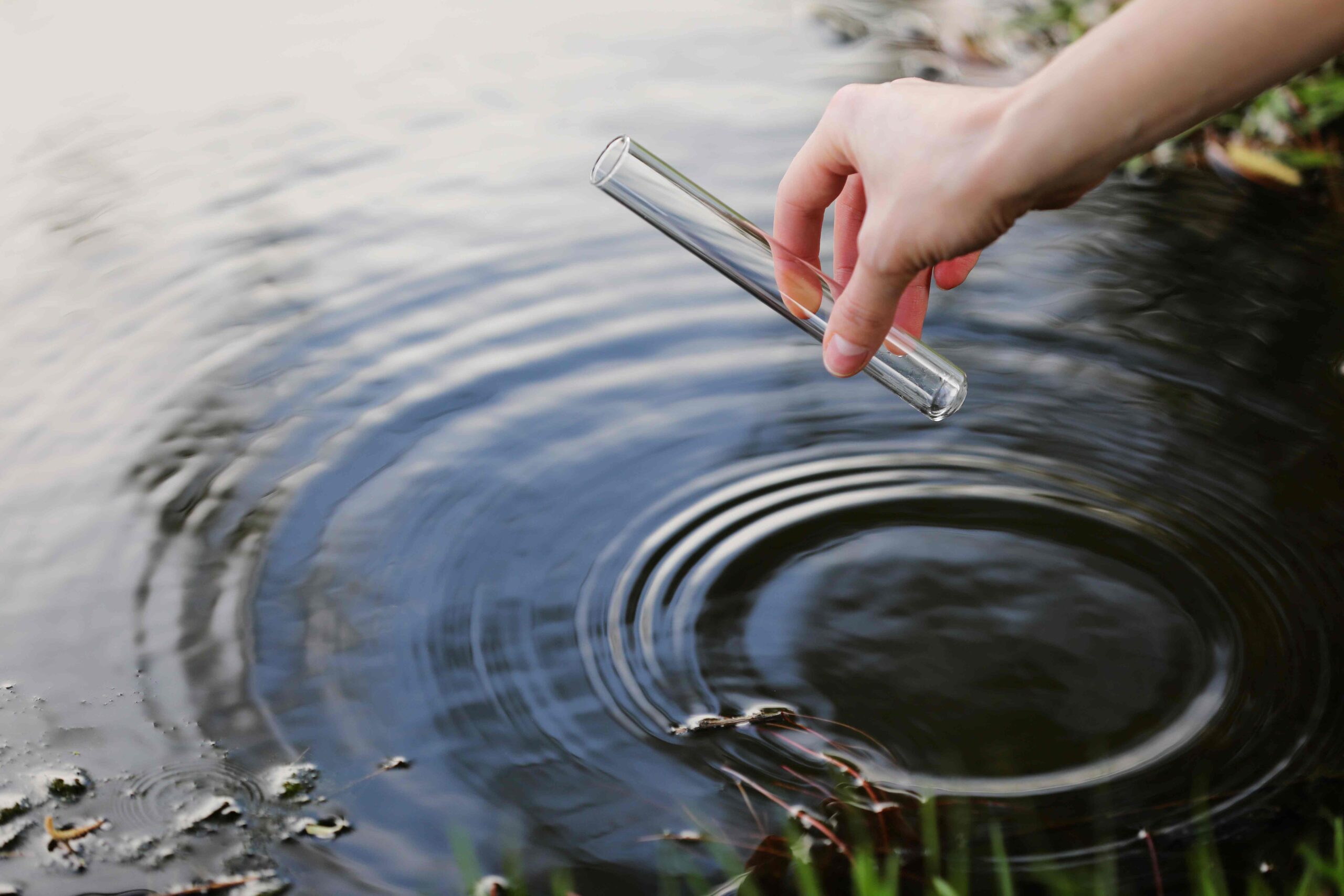 Water is takes. Water sampling. Hand collects Water. Fetch Water into a Flask.